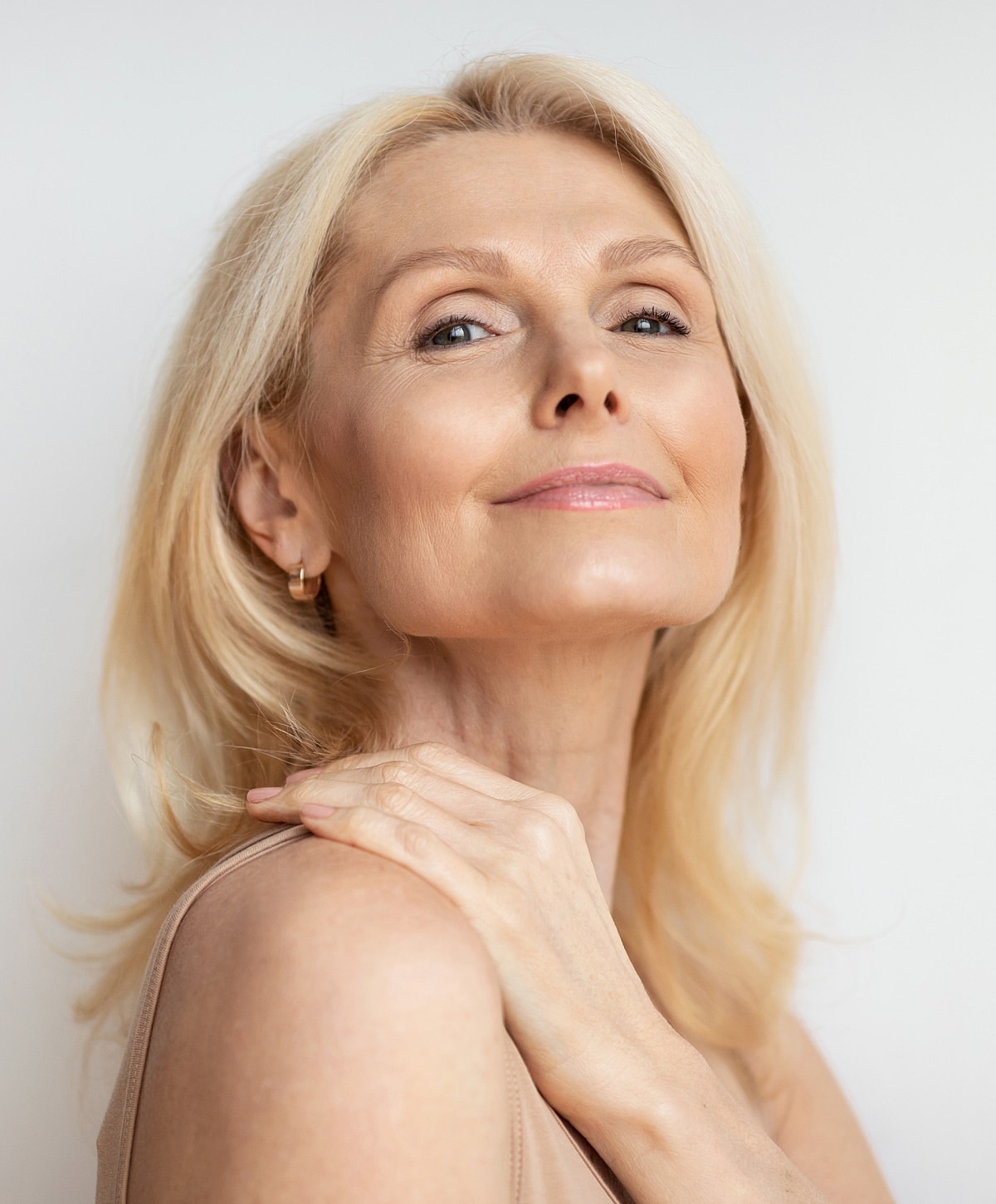 Elegant woman with blonde hair and soft smile.