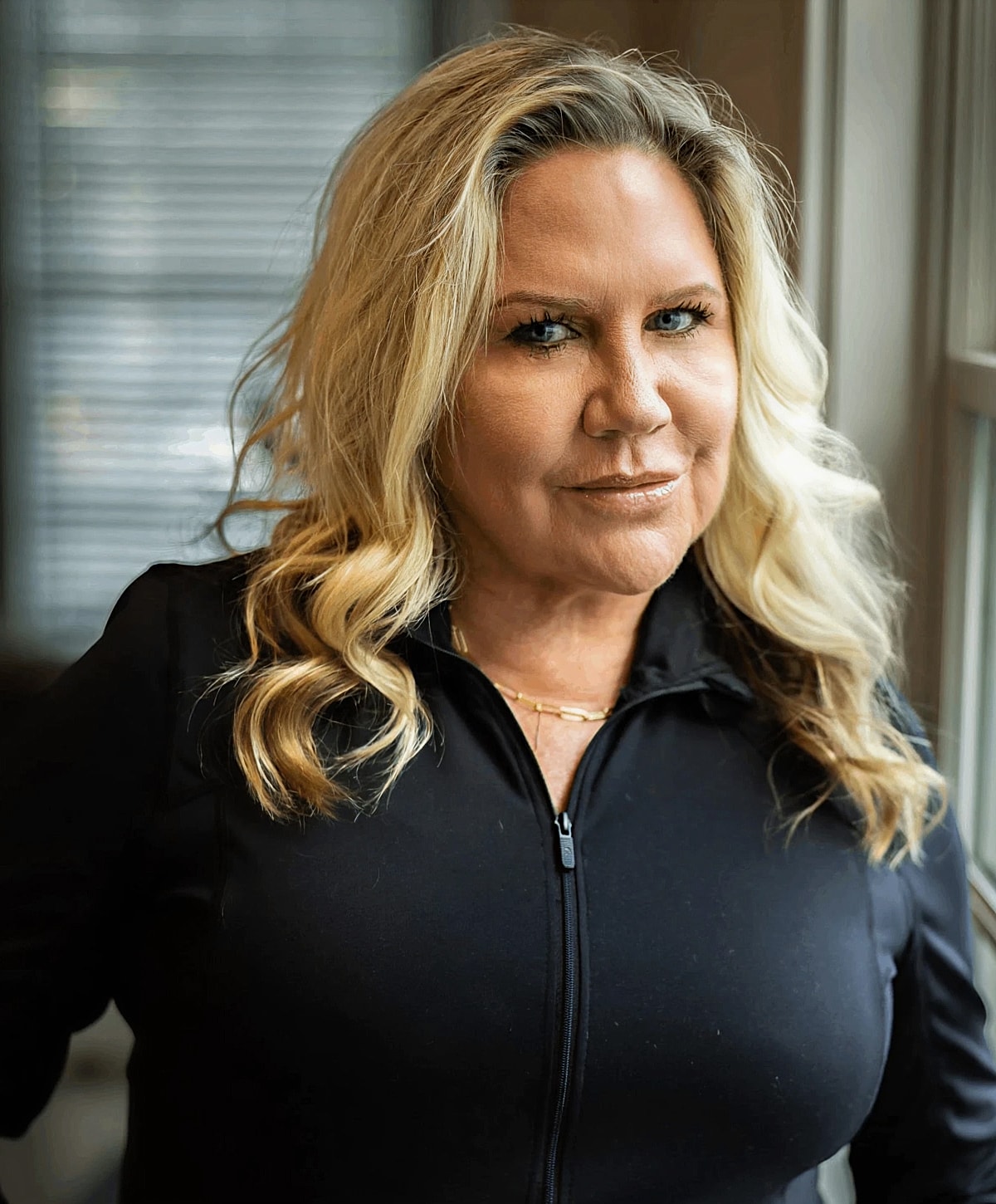 Woman with blonde hair in black attire.