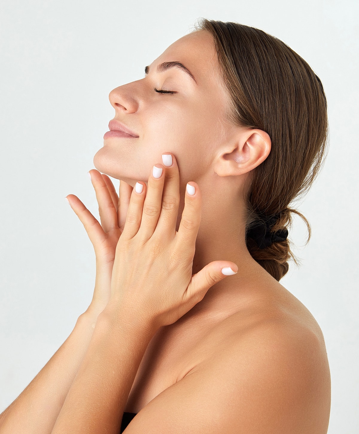 Woman gently touching her face, serene expression.