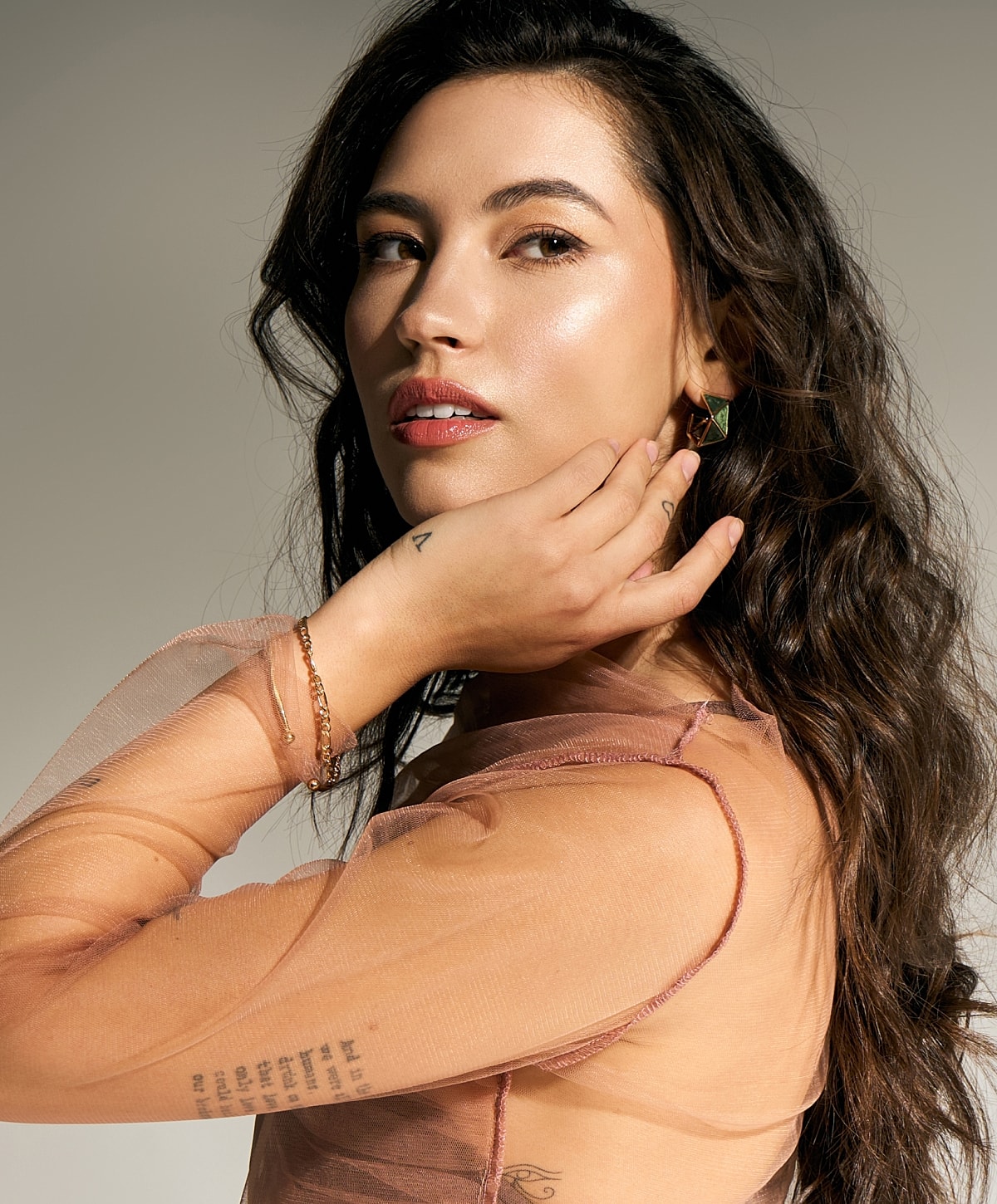 Woman with long hair wearing elegant clothing and jewelry.
