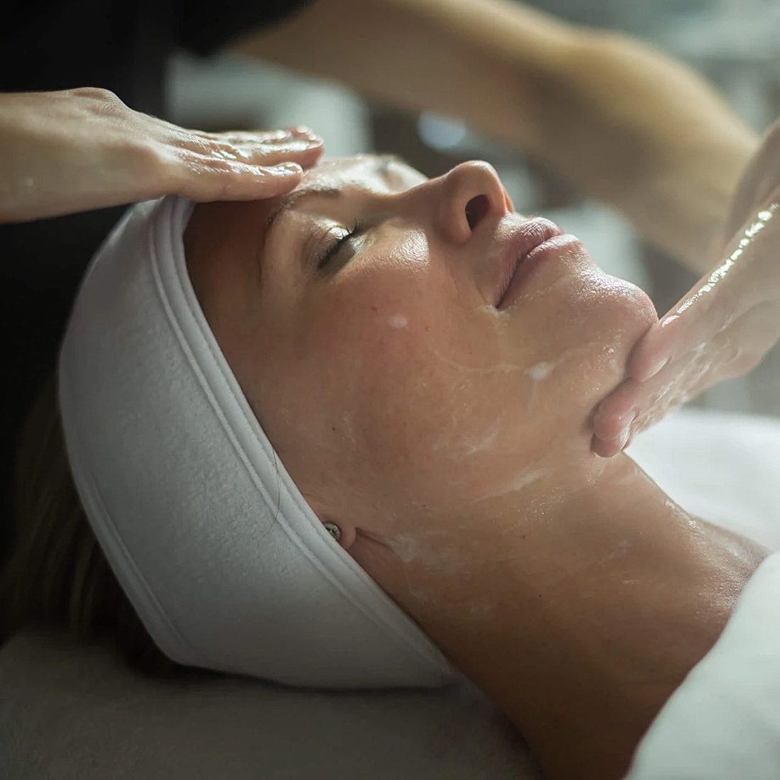 Woman enjoying a facial treatment at spa.